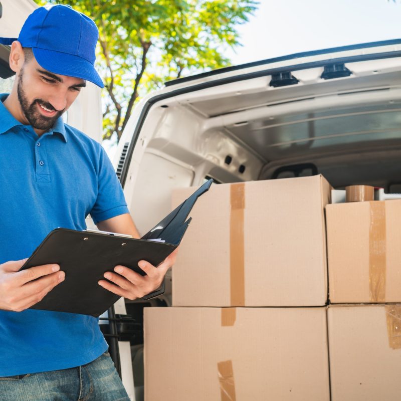 Delivery man checking the products with checklist.